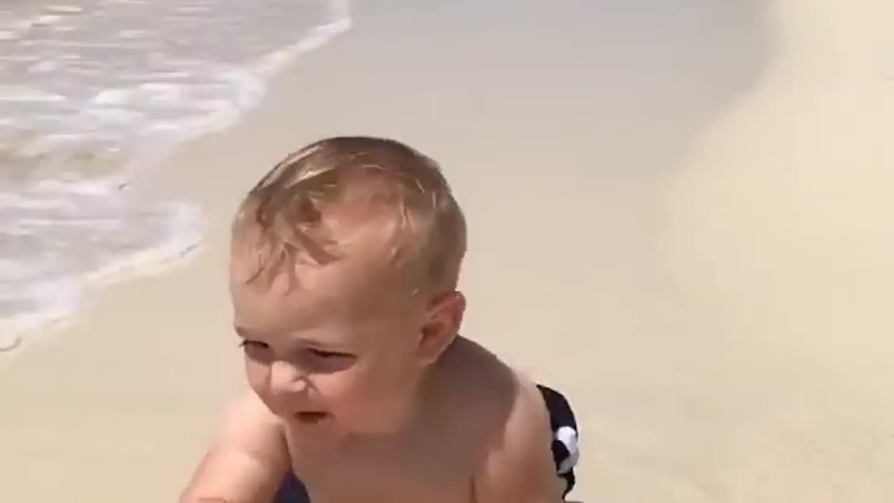 Funny baby reaction on the beach