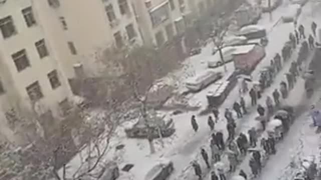 Massive line of Chinese people standing in the freezing snow to take a fake test