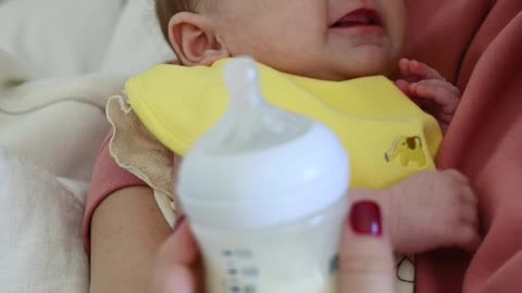 Mother Trying to Feed Her Crying Baby