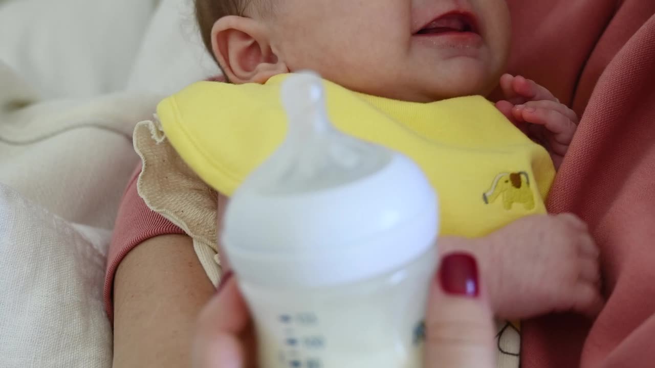 Mother Trying to Feed Her Crying Baby