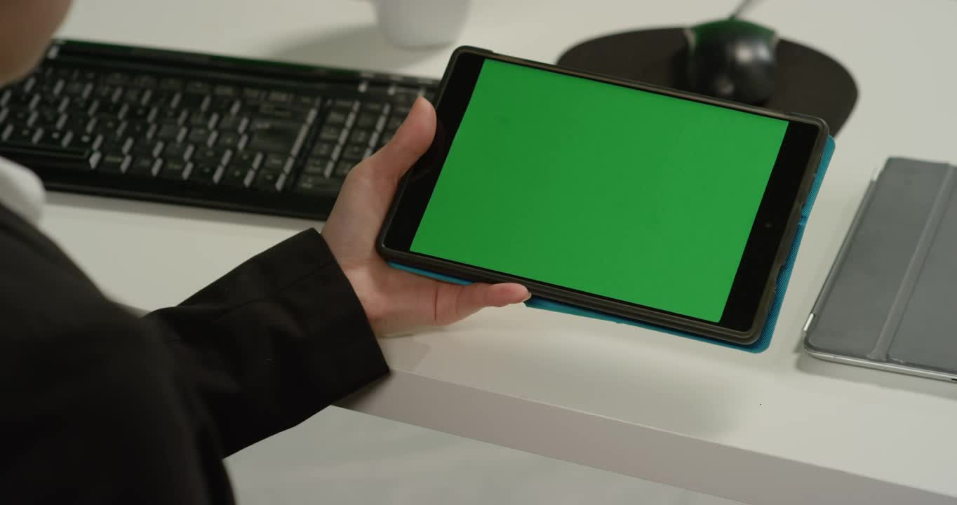 CU Woman at Desk Holding Tablet with Green Screen