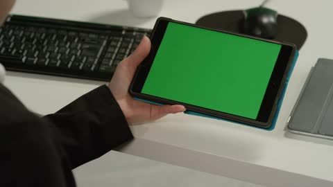 CU Woman at Desk Holding Tablet with Green Screen