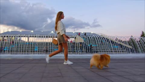 Young girl Walking with Cute Dog on a City Street