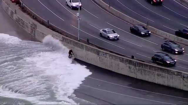 Guy on bike gets pummeled by Lake Michigan waves