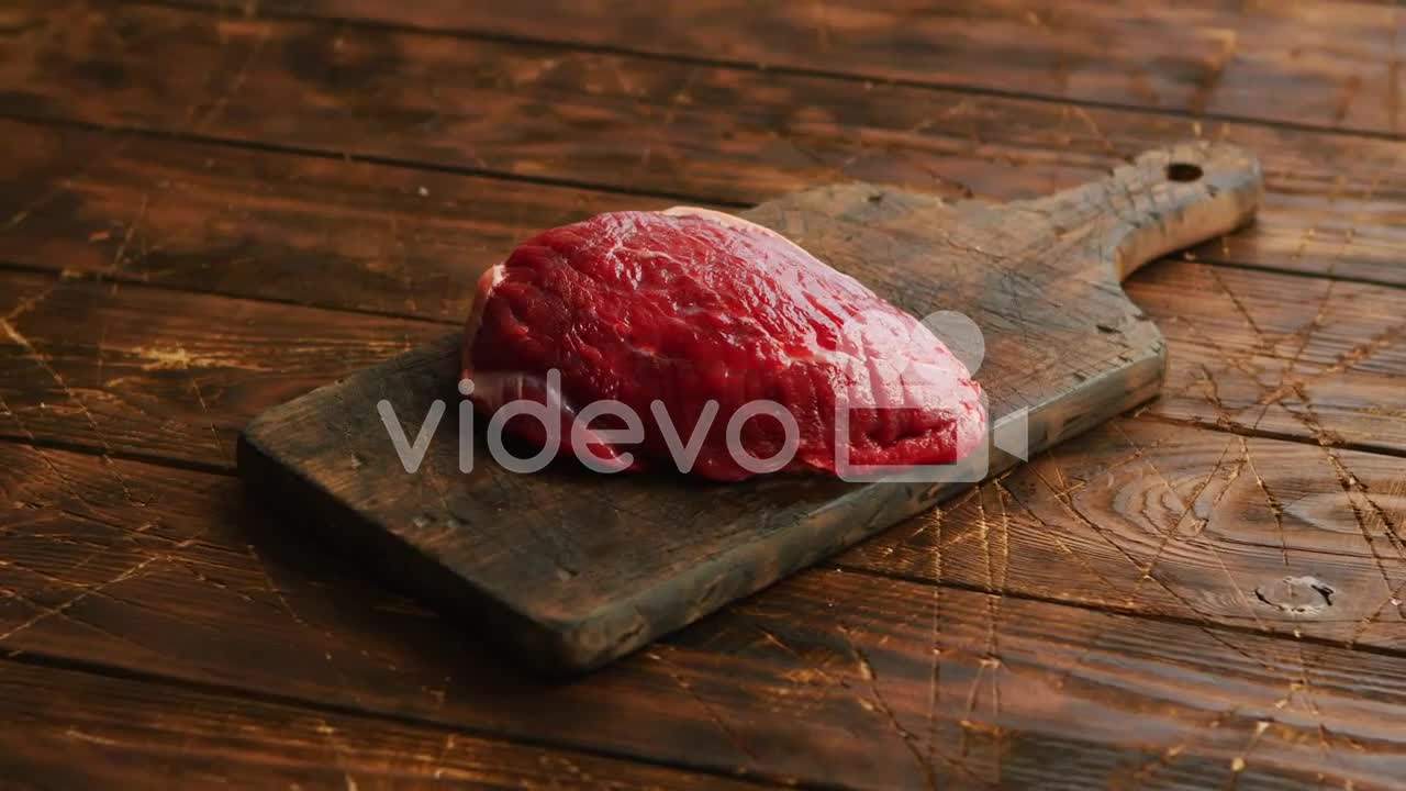 Big fresh piece of meat laid on wooden cutting board