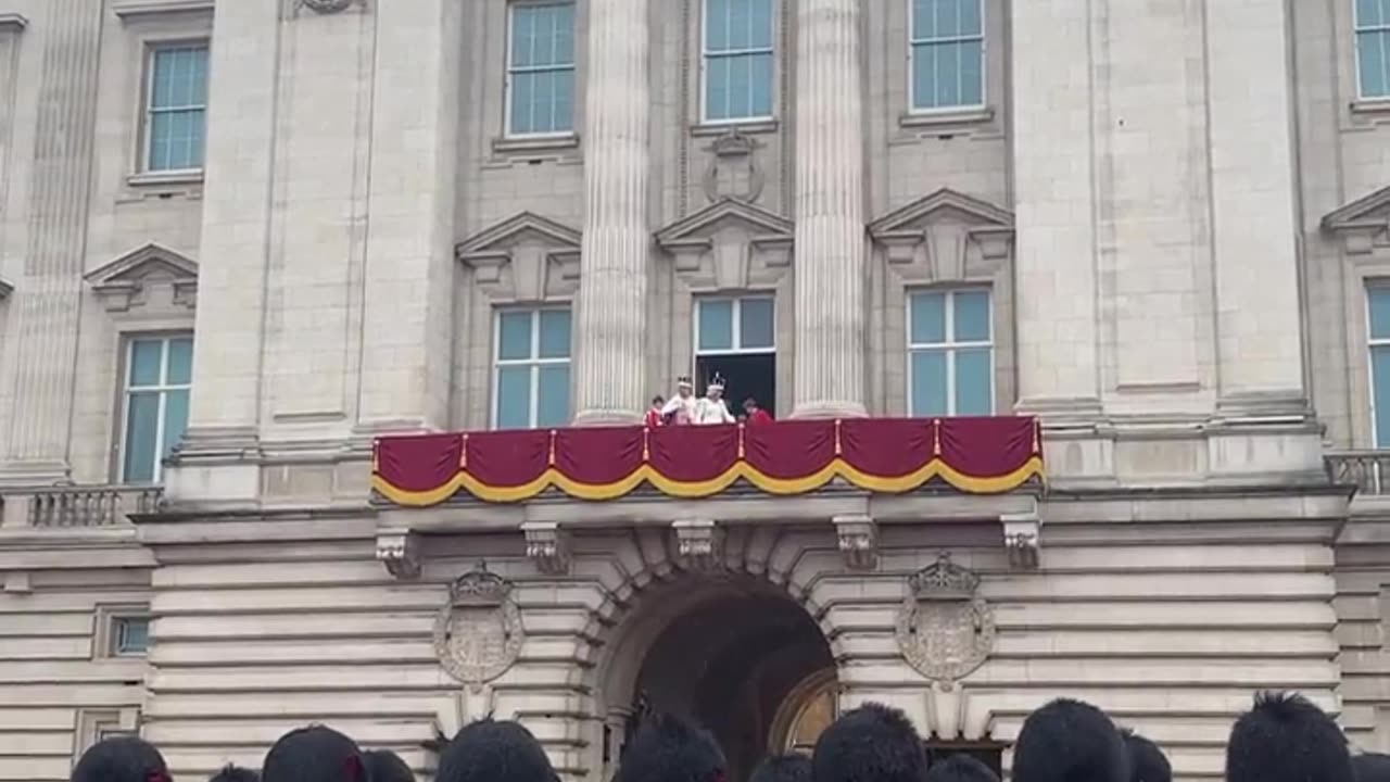 Rei Charles III e rainha Camilla acenam para o público na varanda do Palácio de Buckingham