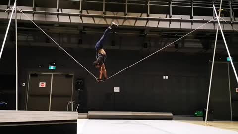 Man Balances In Upside Down Position And Walks On a Slackwire