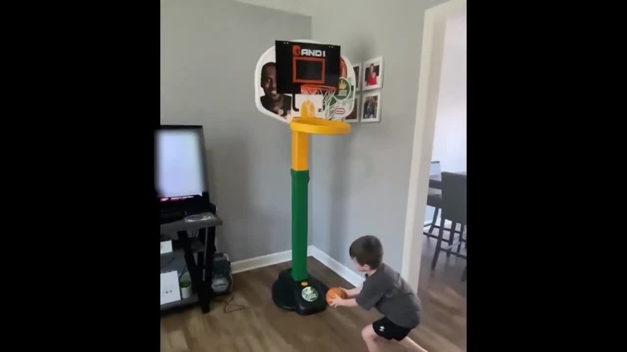 Kid Performs Cool Trick Shots By Putting Different Balls Through Mini Basketball Hoop