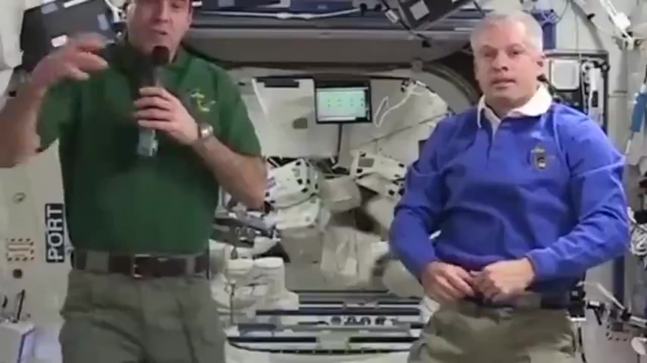 Astronaut in the background forgets to cover his cable during a live TV broadcast