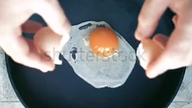 Fried eggs in a pan. Broken egg falls into the frying pan