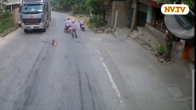 Caminhão vindo e bebê senta na estrada.