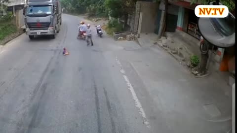 Caminhão vindo e bebê senta na estrada.