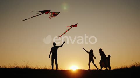 Active Family with Children Launches Kites in a Picturesque Place at Sunset