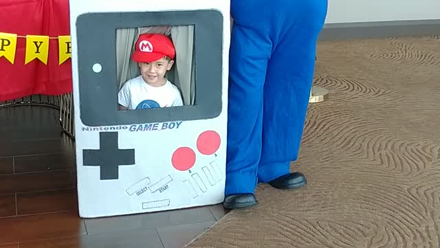 Houston mascot party character Mario poses for pictures at the Gameboy photo prop at a birthday