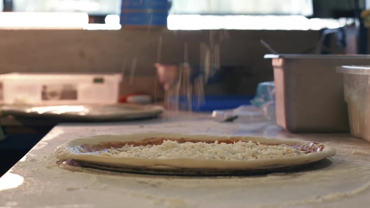 Spreading cheese on a pizza