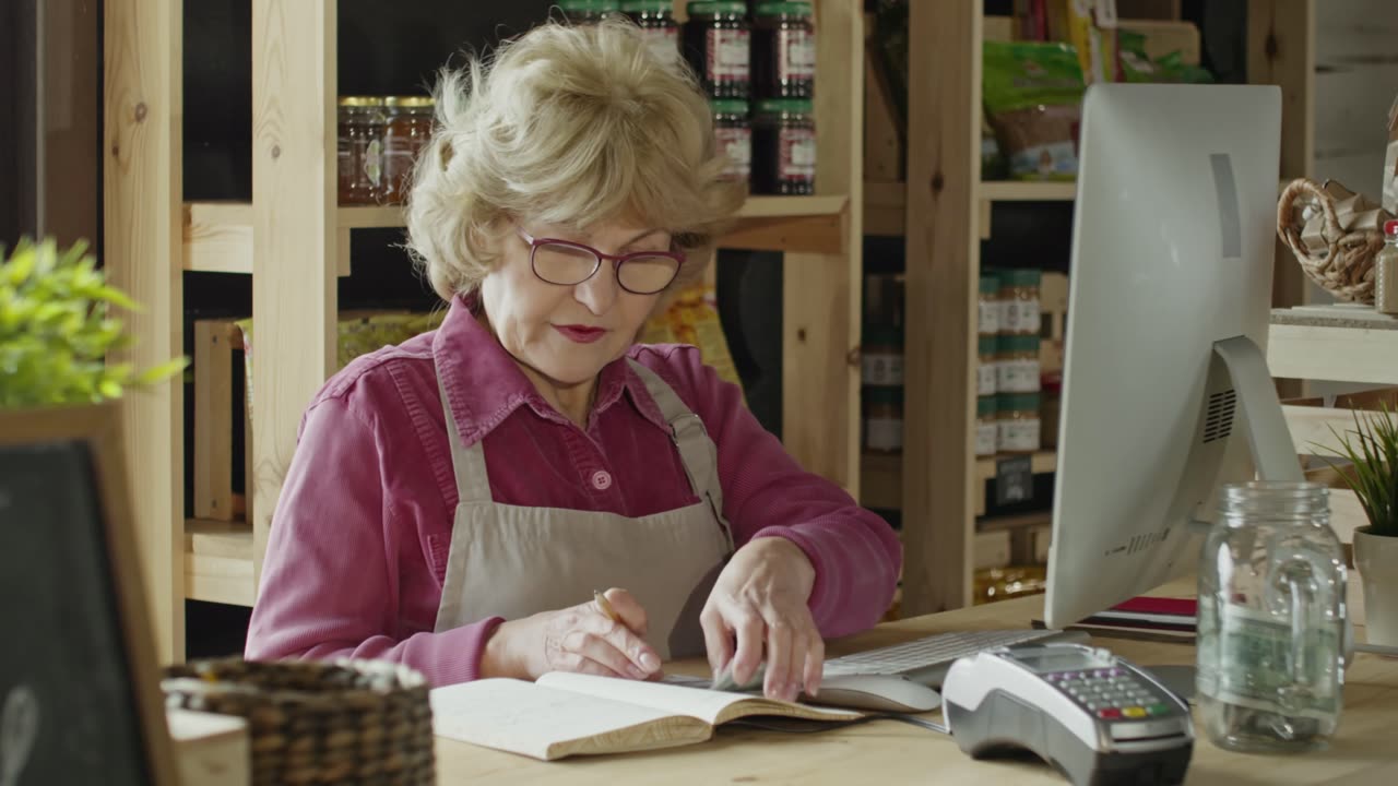 A Woman Busy Computing Money Behind The Counter