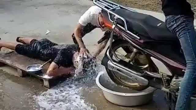 A man who washes his hair on a motorcycle