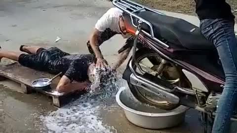 A man who washes his hair on a motorcycle