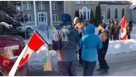 A counter-protestor blocks road and fakes being hit by a Freedom Convoy truck while wearing a mask