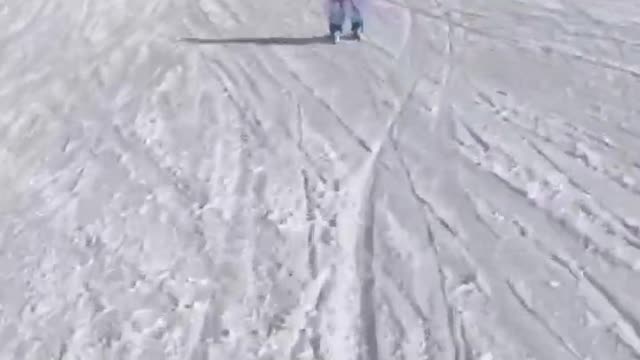 Little Kid Joyfully Skis Downhill on Snow Covered Terrai