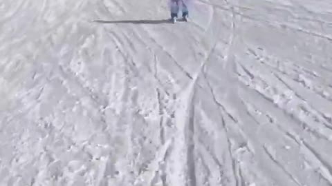 Little Kid Joyfully Skis Downhill on Snow Covered Terrai