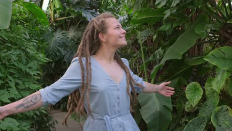 a woman turning round a greenhouse