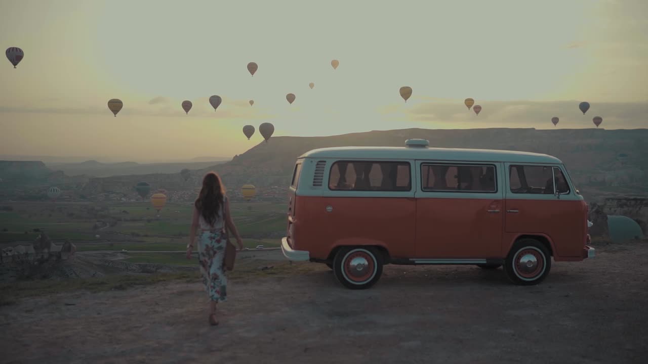 A View Of Hot-Air Balloons In The Air And Woman Riding Her Vehicle