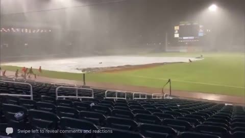 Guy Trying to put Cover on Baseball Ground Gets Blown Away by Gust of Wind