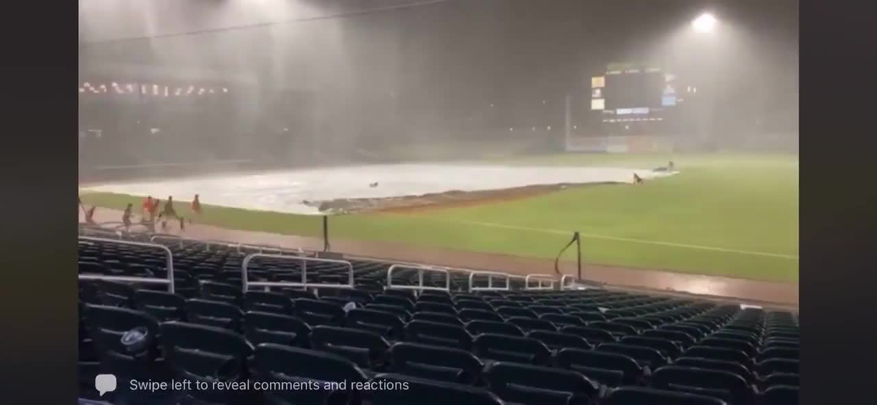 Guy Trying to put Cover on Baseball Ground Gets Blown Away by Gust of Wind