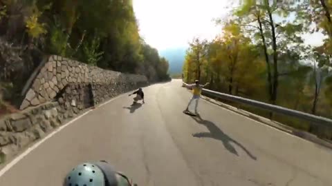 Men Perform Tricks Enroute Downhill on Longboards