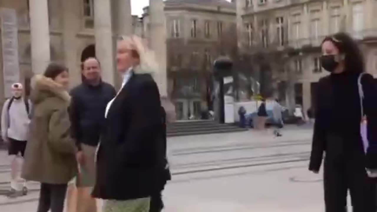 The reactions of the French people towards someone waving a Russian flag in a busy main street