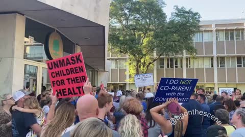 Parents sing USA national anthem outside county board meeting in Oakland County, Michigan Sep. 2021