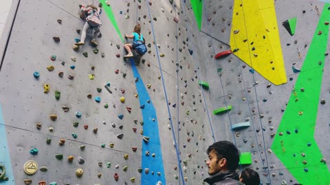 Two little girls climbing wall