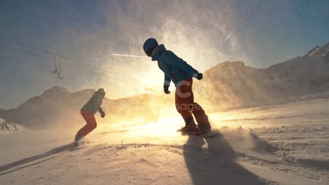 Wide speed ramp tracking shot of two snowboard riders riding