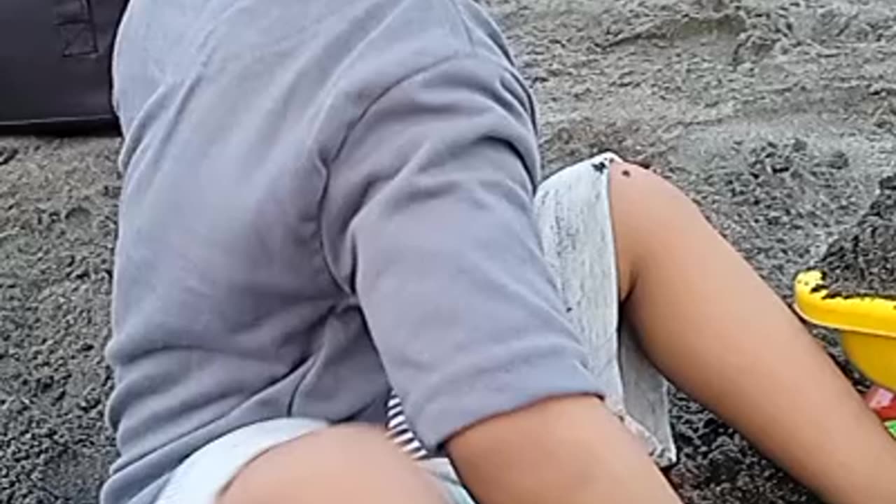 children play in the sand on the beach