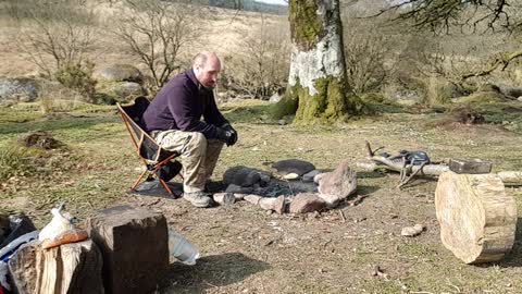 Cooking garlic naan bread on a campfire.