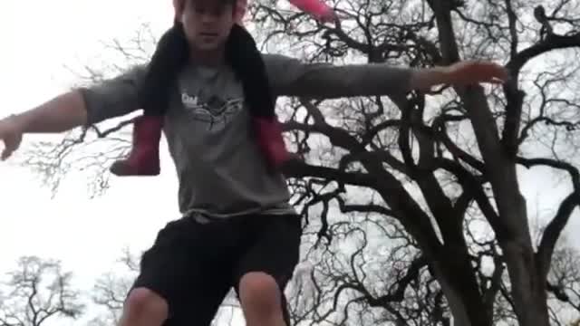 Father Picks Up Daughter On His Neck While Balancing Over a Wooden Plank And Roller