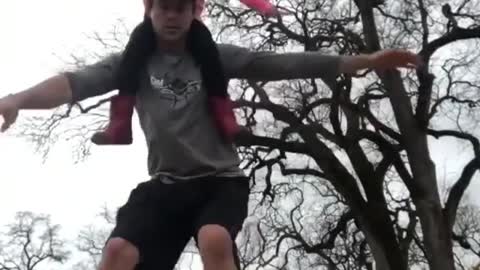 Father Picks Up Daughter On His Neck While Balancing Over a Wooden Plank And Roller