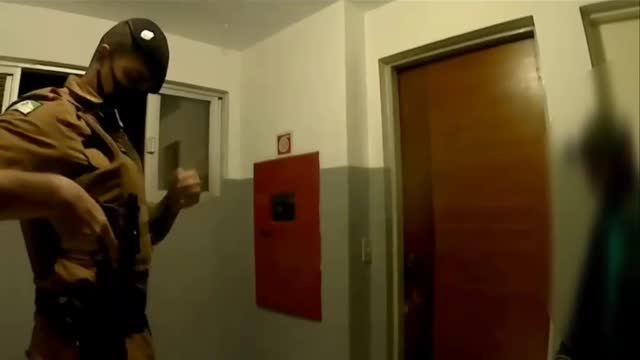 Brazil policeman knocking down door