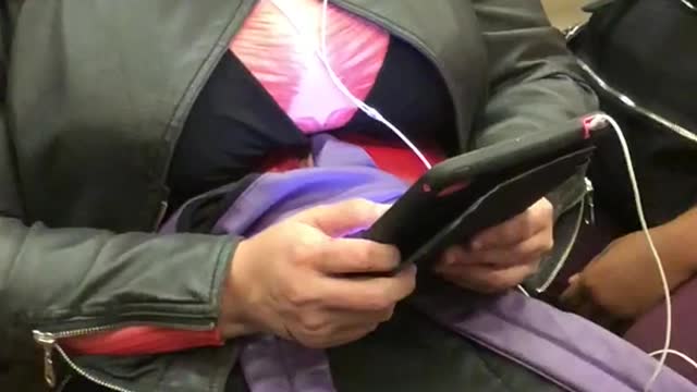 Woman in costume and blonde wig on phone on train