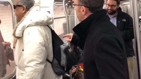 Two men argue about playing music without headphones on subway train