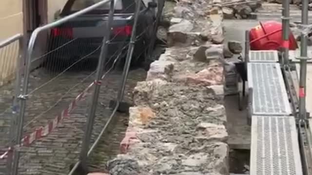 Car Squeezes Past Construction Fence