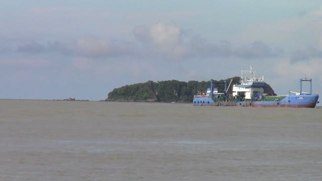 It is not a trick but Huge cargo ship sailing across an Island