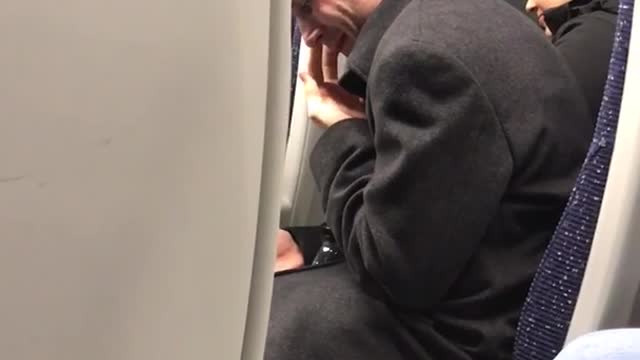 Man black sweater picking nose on train secretly