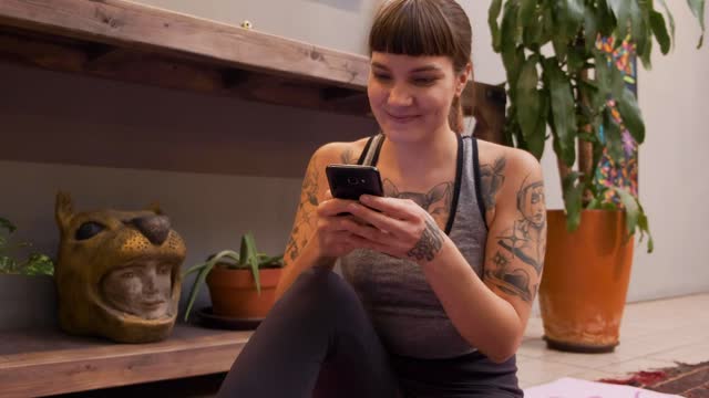 Young woman on her cell phone after training