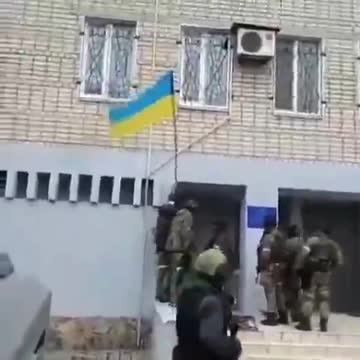 Soldiers of the Ingush riot police remove the Ukrainian flag from the wall