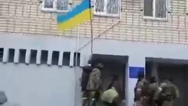 Soldiers of the Ingush riot police remove the Ukrainian flag from the wall