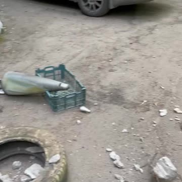 Ukraine War - A Donetsk woman shows the remains of a MLRS shell