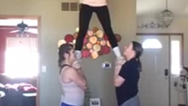 Three girls cheer middle fall down