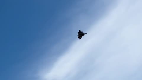 🇷🇺A Su-57 fighter jet flying overhead with missiles on external mounts.